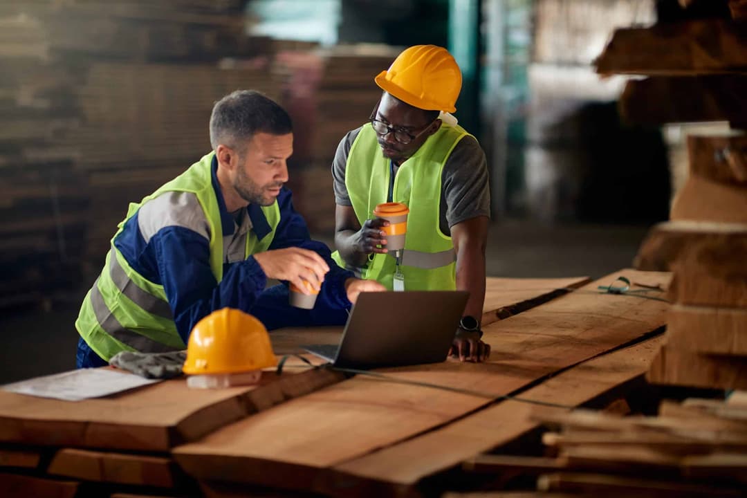 African,American,Worker,And,His,Colleagues,Using,Laptop,While,Drinking